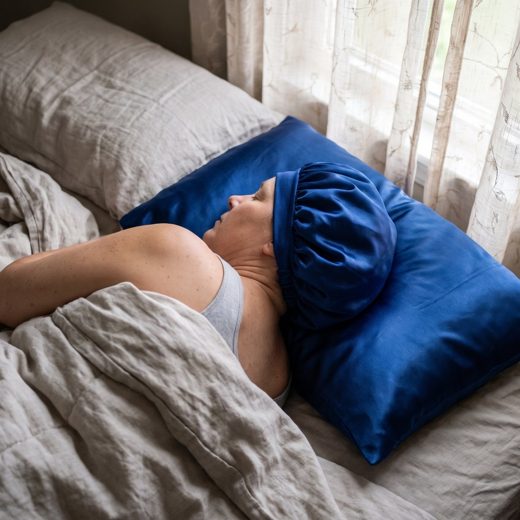 A woman asleep in a satin bonnet